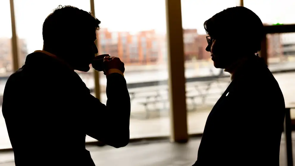 Two people drinking coffee and talking