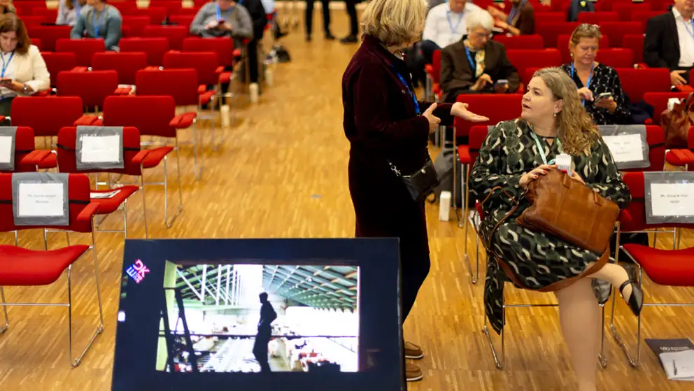 Dr. Charlotte Vilstrup Castle, Chief Veterinary Officer of Denmark talking to woman.