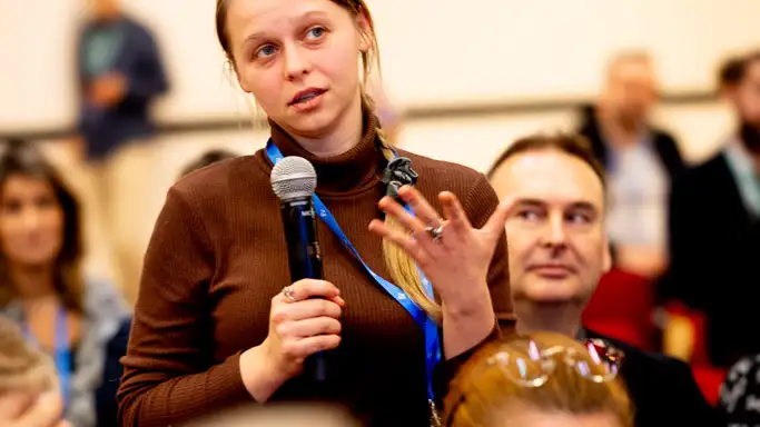 Woman with microphone asking a question.
